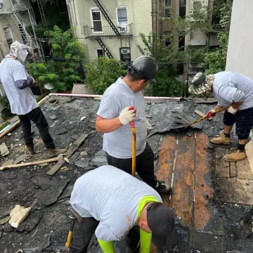 four people working for removal of the roof to asses the damage